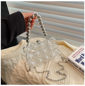 Close-up of transparent acrylic clutch bag with bubble texture and silver beaded handle
