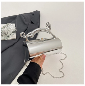 Macro shot of silver mirror cylinder clutch with leopard handle and metal chain strap
