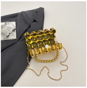 Detail of open gold bubble-shaped acrylic evening bag with beaded handle and chain strap