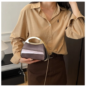 Close-up of metallic purple evening bag featuring gold handle and chain shoulder strap