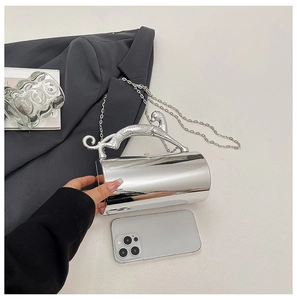 Close-up of silver leopard handle and mirrored cylindrical shell of the luxury evening clutch