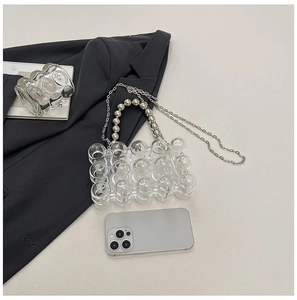 Mini acrylic egg shell bag with bubble texture shown next to a smartphone for size