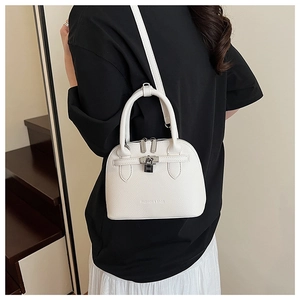 Detailansicht der weißen Muschelhandtasche mit strukturiertem Leder und verstellbarem Gurt
