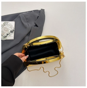 Detail view of gold semi-circle evening clutch bag with hollow handle and metal chain