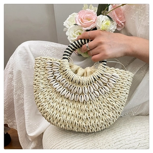 Detail of shell-decorated woven straw bag with spiral handles and drawstring liner