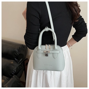 Detail der mintgrünen Shell-Bag mit Lychee-Muster als Umhängetasche am Model