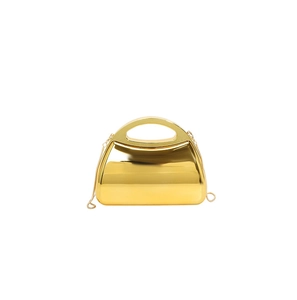 Close-up of luxury gold evening clutch with mirror finish, metal handle and chain strap