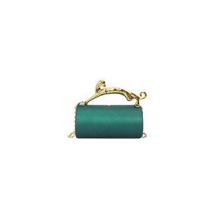 Detail of emerald green evening bag with gold leopard handle and chain strap