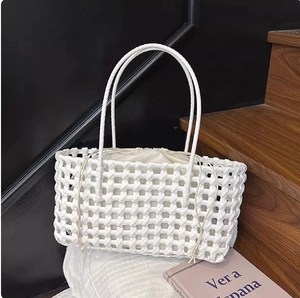 Detail of white woven tote bag featuring a rectangular structure and drawstring liner