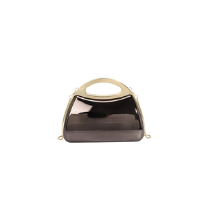 Detail of glossy metallic finish of gun-grey evening clutch with gold metal handle