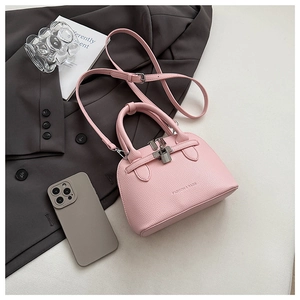 Detailansicht einer rosa Handtasche in Muschelform mit Silberverschluss und Lederstruktur