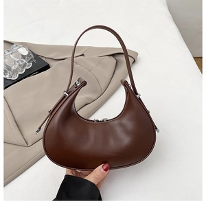 Detailed close-up of dark brown crescent hobo bag with sleek finish and silver hardware