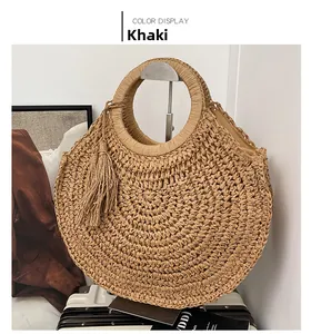 Detail view of khaki woven straw bag showing intricate texture and decorative tassels
