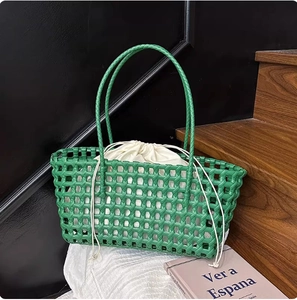 Detail of green woven tote bag with white drawstring liner on wooden steps