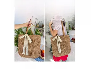 Detail of raffia woven tote bag with white lace bow showing handheld and shoulder styles