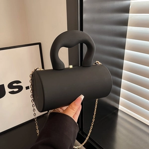 Sac cylindrique noir mat minimaliste avec chaîne dorée et large poignée en arc