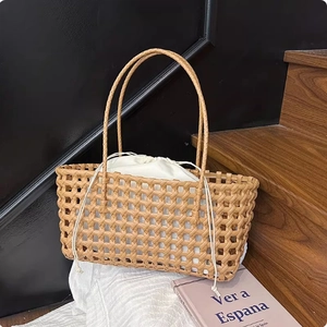 Detail of hand-woven caramel tote bag with hollow grid pattern and white drawstring inner bag