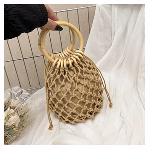 Detail of bohemian cotton rope woven bucket bag with round wooden handles and drawstring