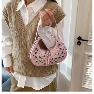 Detail of pink hobo bag featuring silver rivets and studs on matte faux leather surface
