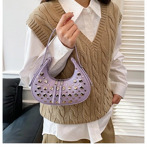 Detail view of purple crescent bag featuring dense silver studs and dual metal zippers