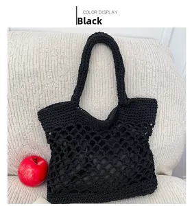 Dettaglio della borsa tote nera intrecciata con motivo a rete e fodera interna in tessuto