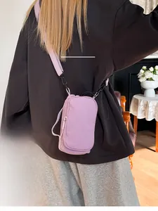 Lavender purple nylon mini crossbody bag shown on a model in a cozy home setting