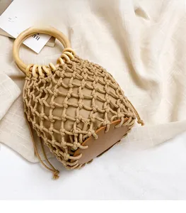 Detail view of woven bucket bag with round wooden handle and drawstring liner