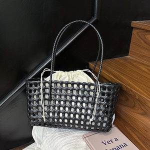 Black handwoven hollow tote bag with cream canvas drawstring inner pouch for beach and travel