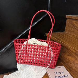 Red woven basket bag with cream drawstring liner on wooden steps in minimalist style