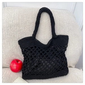 Detailed macro of black hollow woven cotton tote bag with interior lining and dual handles