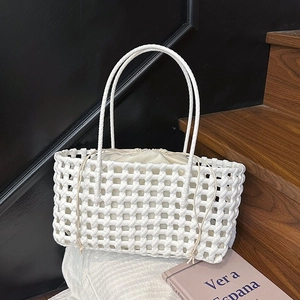 Detailed texture of white hand-woven tote bag with drawstring inner pouch and slim handles