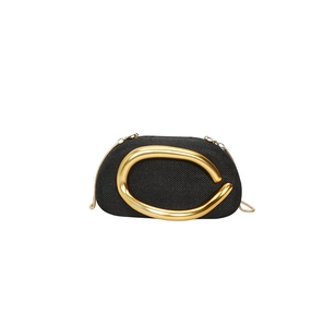 Detail of black woven evening clutch featuring a sleek gold curved metal handle and chain