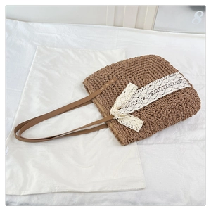 Detail of raffia woven tote with delicate white lace trim and large bow decoration