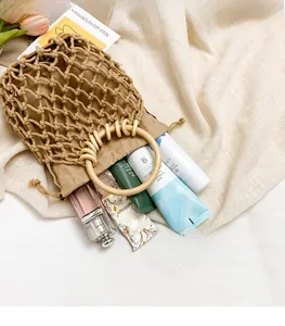Detail of woven cotton beach bag with wooden handles, drawstring liner, and spacious interior