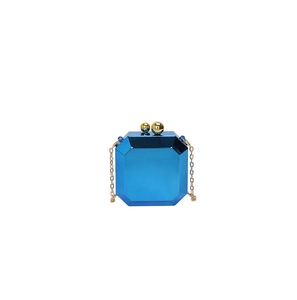 Macro detail of octagonal candy-colored acrylic mirror evening bag with gold sphere clasps