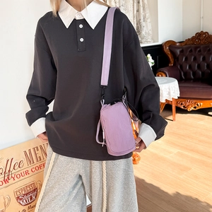 Close-up of light purple vertical crossbody bag with adjustable wide strap on a model