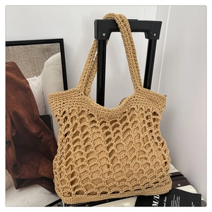 Detailed close-up of a woven cotton rope tote bag hanging on a suitcase handle
