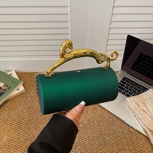 Dark green cylindrical evening bag with gold leopard handle and chain strap