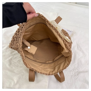 Detail view of woven raffia tote interior with fabric lining and secure zipper pocket