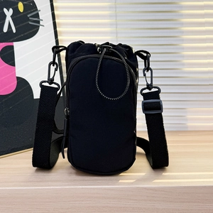 Detail of minimalist black nylon crossbody phone bag with drawstring and adjustable strap