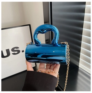 Detail of a mini cylindrical handbag with blue metallic mirror finish and gold chain
