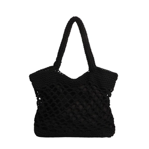 Detailed close-up of a black hand-woven cotton rope tote bag with hollow mesh design