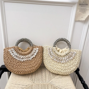 Handmade half-moon straw beach bag with shell decor and striped handle for women