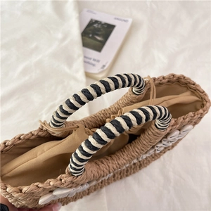 Handmade half-round straw bag with shell trim and striped rope handle for beach vacation