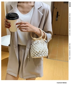 Detail of white cotton rope woven bucket bag with circular wooden handles and inner pouch