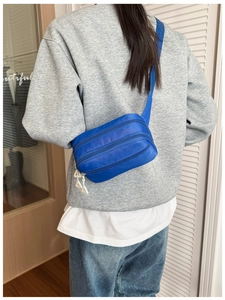 Blaue Kinder-Gürteltasche mit drei Reißverschlussfächern in der Rückansicht getragen