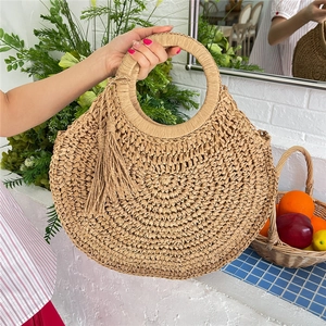 Handcrafted round straw tote bag with tassel fringe for summer beach vacation