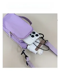 Top view of purple nylon crossbody bag showing spacious interior with phone and water bottle