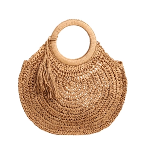 Handcrafted straw handbag with round handles and tassel detail on white background