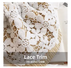 Detailed view of intricate white floral lace patterns on a summer straw bucket bag